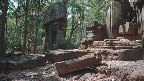 Ancient-Angkor-Wat-temple-ruins-surrounded-by-forest-in-bright-daylight,-still-and-serene