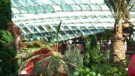 Turistas-Que-Visitan-La-Atracción-Histórica,-El-Invernadero-De-Cristal-Más-Grande-Del-Mundo,-El-Invernadero-Con-Cúpula-De-Flores-En-Los-Jardines-Junto-A-La-Bahía