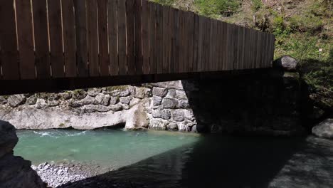 Drohnenflug-Unter-Einer-Brücke-Mit-Wunderschönem-Gebirgsfluss-Mit-Türkisfarbenem-Wasser