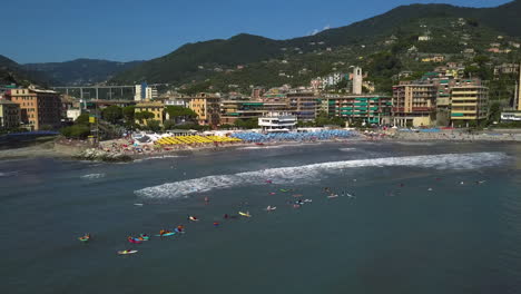 Drone-shot-of-surfers-waiting-for-waves-on-the-coastline-of-Recco,-Liguria,-Italy