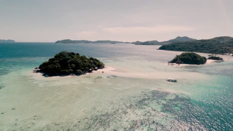 Aerial-drone-shot-in-Palawan-Coron-in-the-Philippines-when-island-hopping-in-the-asian-sea-with-a-motorboat-on-a-sunny-day-and-many-beaches,-palm-trees-and-eating-seafood-playing-with-a-dog