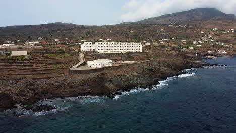 Vista-Aérea-Alrededor-Del-Hotel-En-La-Costa-De-Pantelleria,-Soleada-Italia---órbita,-Disparo-De-Drones