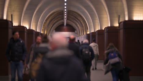 Gente-Fuera-De-Foco-Caminando-A-Través-De-Un-Túnel-En-Arco-En-La-Estación-De-Tren-Del-Puente-De-Londres-En-Londres,-Reino-Unido