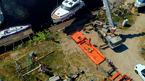 Bajando-Un-Barco-De-Lujo-Al-Agua-Con-Autogrúa,-Vista-Aérea.