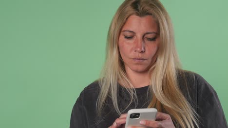 Mujer-Enviando-Mensajes-De-Texto-En-Un-Teléfono-Inteligente-Con-Expresión-Frustrada-Pantalla-Verde-Croma-Key