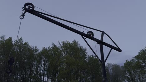 Simple-Rusted-Homemade-Crane-With-Three-Pulleys-Surrounded-By-Trees