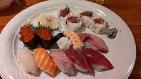 White-plate-of-assorted,-colorful,-fresh-sushi---push-in
