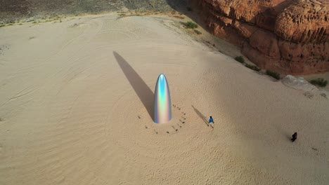 Aerial-view-of-a-man-walking-to-the-Gisela-Colon-monolith,-at-the-Desert-x,-in-sunny-Al-ula,-Saudi-Arabia