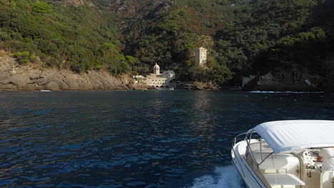 Aerial-view-of-a-couple-on-a-romantic-boat-trip,-at-the-San-Fruttuoso-abbey,-in-sunny-Italy