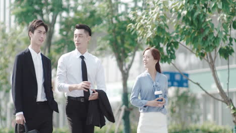 Male-and-female-company-workers-walking-together-with-their-handsome-boss-and-giving-him-their-ideas-about-new-project