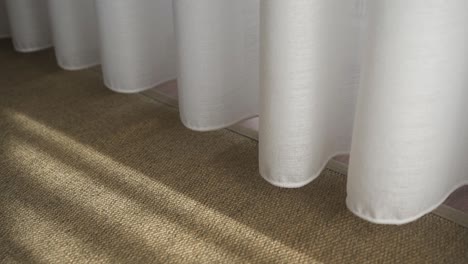 Close-up-shot-of-white-textile-curtains-roll-right,-Sunlight-and-Shadows-Concept