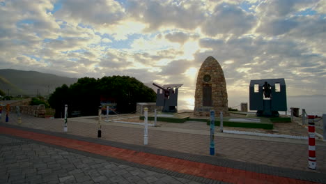 Hermanus-War-Memorial-monument-backlit-by-epic-sunrise-sky-over-Walker-Bay