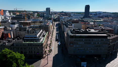 Toma-Aérea-Inclinada-Siguiendo-Un-Tranvía-En-Las-Calles-De-Tampere,-Día-De-Verano-En-Finlandia.