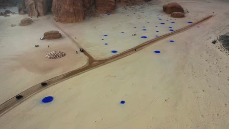 Aerial-view-of-cars-driving-in-middle-of-art-in-Desert-X-AlUla,-Saudi-Arabia