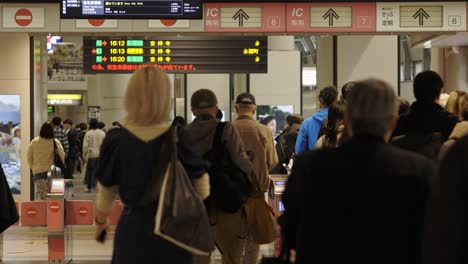 Shibuya-Train-Station,-Commuters-walking-through-ticket-gates,-Tokyo,-Japan