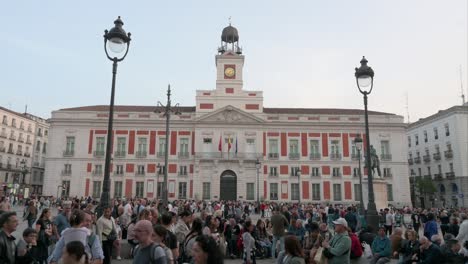 Wide-view-of-large-crowds-of-people-gathering-and-spending-their-evening-at-the-Puerta-del-Sol,-an-iconic-landmark-of-Madrid