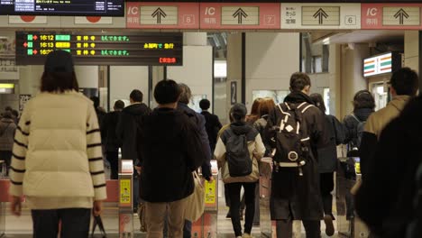 Shibuya-Train-Station,-Commuters-walking-through-ticket-gates,-Tokyo,-Japan