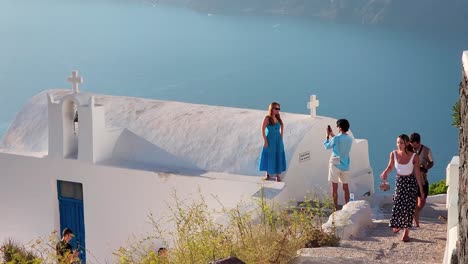 Santorini-En-Grecia,-Los-Turistas-Se-Toman-Fotografías-Unos-A-Otros-Para-Capturar-Los-Recuerdos-De-Los-Agradables-Momentos-De-Las-Vacaciones-Junto-Al-Mar