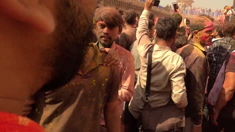 pov-shot-A-group-of-people-coming-to-the-temple-are-being-welcomed-in-a-very-excited-and-joyful-manner-by-garlands-of-flowers-and-also-being-painted-with-colours