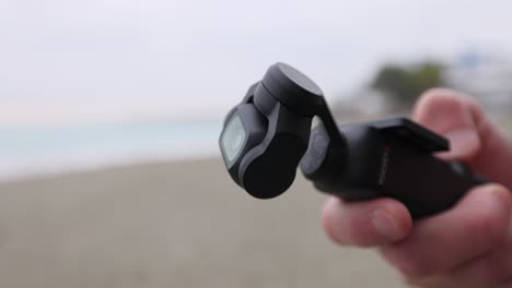 Hand-Holding-A-Pocket-Camera-Rotating-Its-Camera-To-Shoot-Video