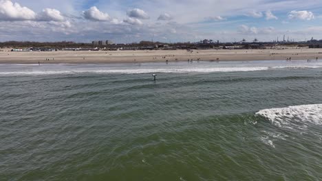 Ein-Mann-Macht-Wingsurfen-Im-Meer-Vor-Der-Küste-Des-Strandes-Von-Hoek-Van-Holland-In-Den-Niederlanden-–-Luftaufnahme-Einer-Drohne