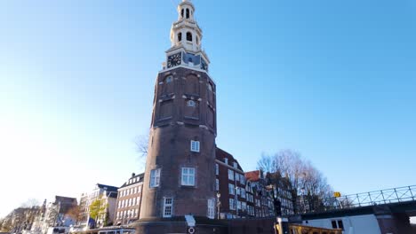 Sailing-Past-Montelbaanstoren-Tower-On-Bank-Of-Oudeschans-Canal-In-Amsterdam-From-River-Cruise