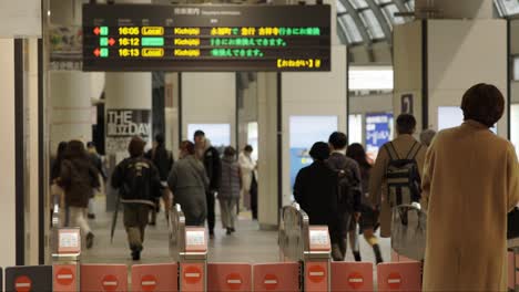 Shibuya-Train-Station,-Commuters-walking-through-ticket-gates,-Tokyo,-Japan