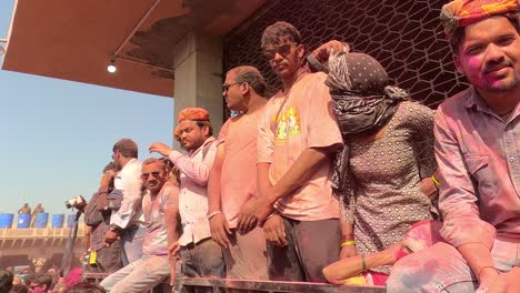 pov-shot-A-very-large-number-of-people-are-enjoying-Holi-enthusiastically-in-the-temple-and-some-groups-are-shooting-photos-and-videos-on-cameras-and-phones