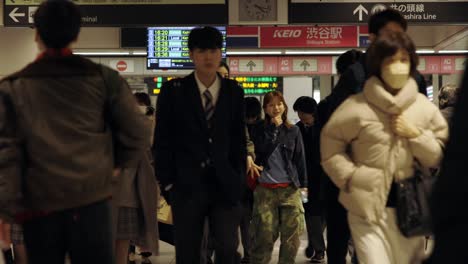 Shibuya-Train-Station,-Commuters-walking-through-ticket-gates,-Tokyo,-Japan