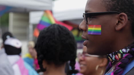 Eine-Nahaufnahme-Eines-Festivalbesuchers-Mit-Einem-Pride-Flaggenaufkleber-Im-Gesicht-Während-Des-Midmo-Pridefests