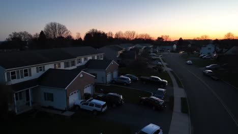 Aerial-view-showing-american-neighborhood-with-garage-and-parking-cars-at-sunset-time