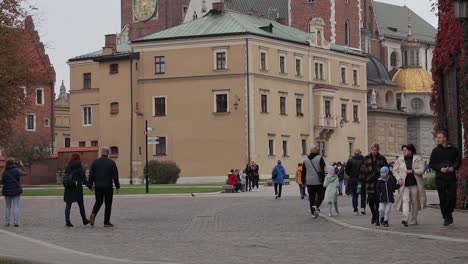 Tourists-Walk-In-The-Background-of-Wawel-Royal-Castle-in-Krakow,-Poland
