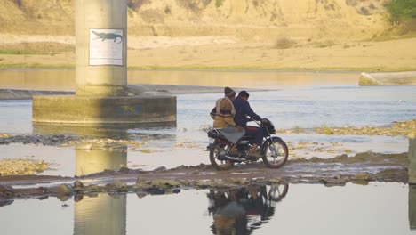 Pilgrims-or-group-of-villagers-of-bundelkhand-culture-walking-on-shore-of-a-sindh-river-under-a-bridge