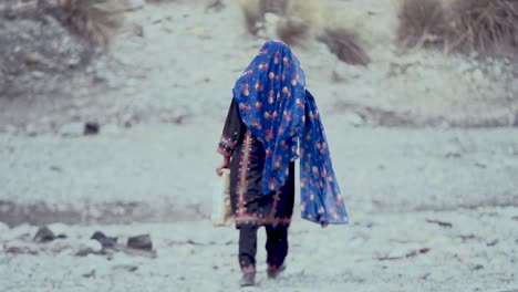 Una-Joven-Pobre-Es-Vista-Alejándose-Sosteniendo-Un-Paquete-De-Ayuda-Como-Parte-De-La-Ayuda-Para-La-Distribución-De-Alimentos-En-Baluchistán.