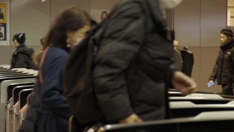 Shibuya-Train-Station,-Commuters-walking-through-ticket-gates,-Tokyo,-Japan