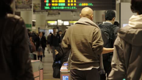 Shibuya-Train-Station,-Commuters-walking-through-ticket-gates,-Tokyo,-Japan