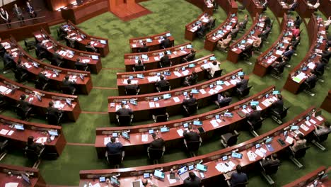 A-tilting-up-view-of-lawmakers-is-seen-at-the-Legislative-Council-building-main-chamber-listening-to-John-Lee-Ka-chiu,-Hong-Kong's-chief-executive,-delivering-the-annual-policy-address-in-Hong-Kong