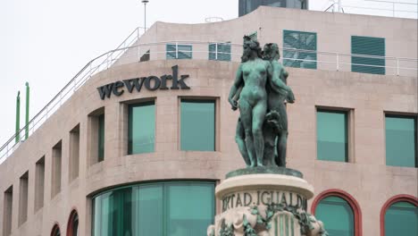 American-coworking-spaces-company,-WeWork-Inc,-space-and-logo-is-seen-on-a-building-facade-in-Spain