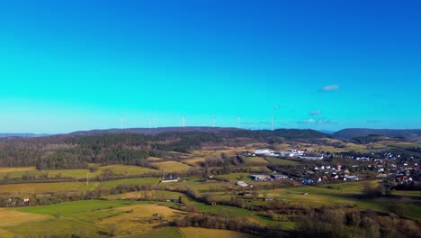 Nachhaltige-Zukunft:-Windräder-Blicken-Auf-Ein-Blühendes-Dorf-Auf-Dem-Land