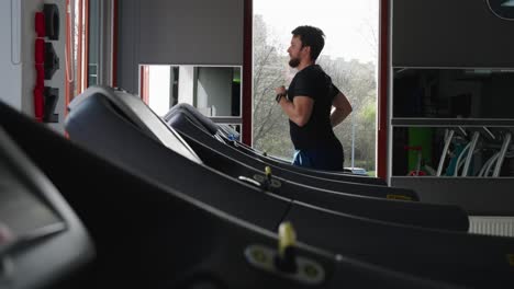 Active-caucasian-male-run-on-electric-treadmill-machine-at-indoor-gym