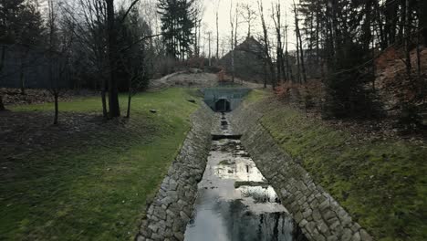 Canal-Afluente-Empedrado-Hasta-La-Presa-Con-Un-Pequeño-Puente-Sobre-El-Que-Se-Hace-Cargo-Un-Corredor.