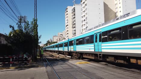 Blue-train-travel-roads-sunny-day,-public-transportation-of-the-city-of-Buenos-Aires-Argentina,-panoramic-shot,-Sarmiento-line,-transit-agent-helps