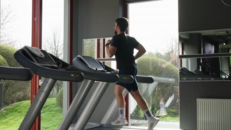 Sportlicher-Mann-Läuft-Auf-Elektrischem-Laufband,-Fitnessmotivation-Und-Hingabe