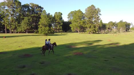 Romantic-afternoon-horse-ride-as-couple-set-off-at-sunset-through-the-forest-trees