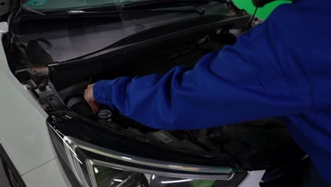 Automotive-mechanic-man-opening-car-hood-to-add-windshield-washer-fluid