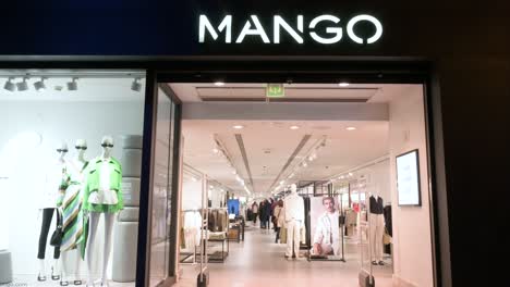 Los-Peatones-Pasan-Por-La-Tienda-De-Mango-De-La-Marca-De-Ropa-Multinacional-Española-Durante-La-Noche-En-España