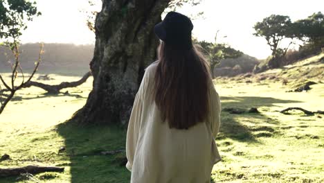 Female-walking-and-looking-into-the-distance-in-wooded-grasslands,-Madiera,-Portugal