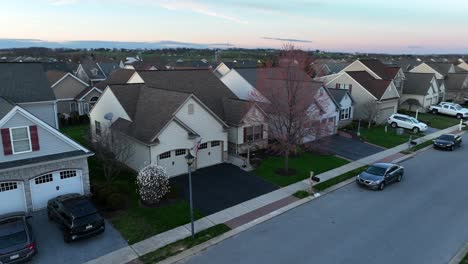 Amerikanisches-Haus-In-Der-Nachbarschaft-Mit-US-Flagge-Und-Autos,-Die-Während-Der-Abenddämmerung-Und-Des-Sonnenuntergangs-Geparkt-Sind