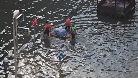 El-19-De-Abril-De-2024,-Se-Entregan-Alimentos-En-Barco-En-Una-Carretera-Inundada-En-El-Norte-De-Los-Emiratos-Árabes-Unidos-Después-De-Unas-Lluvias-Récord.