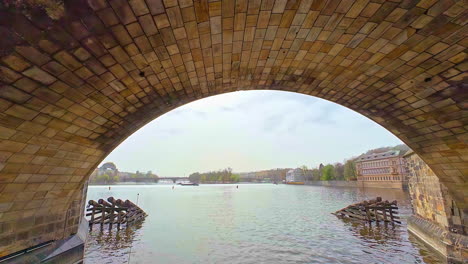 Shot-taken-while-passing-under-Charles-Bridge,-a-historic-bridge-over-the-Vltava-river-in-Prague,-Czech-Republic-on-a-cloudy-day